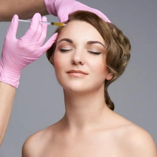 A professional applying a Botox treatment to a client's forehead in a medical environment.
