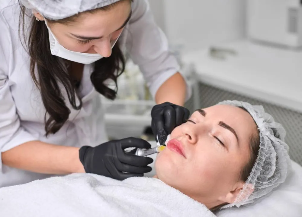 Dermal filler treatment being administered to a client by a professional in a medical setting.