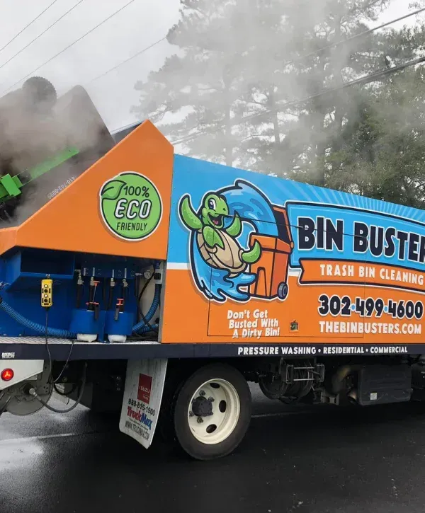 A Bin Buster truck with a cartoon turtle mascot cleaning a green trash can, producing steam.