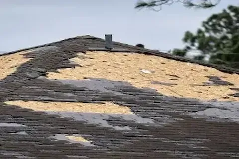 Hail-damaged roof with shingles blown away exposing wood decking in Blaine by Blaine Roofing