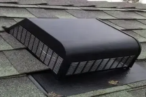 Black dome-style attic roof vent installed on a shingle roof surface