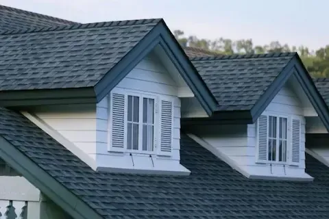 Charcoal gray shingle roof with two white dormers on a residential home in Blaine