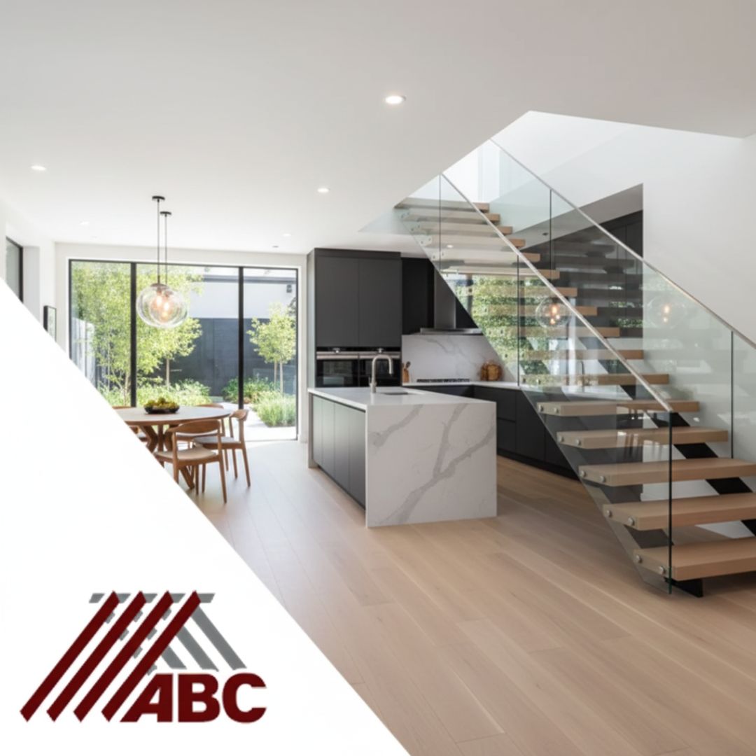 Conroe, Texas Home Restoration project showcasing a rebuilt modern kitchen, open-concept living area, and glass staircase. ABC Restoration specializes in full water damage and fire damage repair and rebuilds in Montgomery County, ensuring quality finishes like hardwood floors and quartz countertops after a disaster. Call us for reliable restoration services in Conroe.