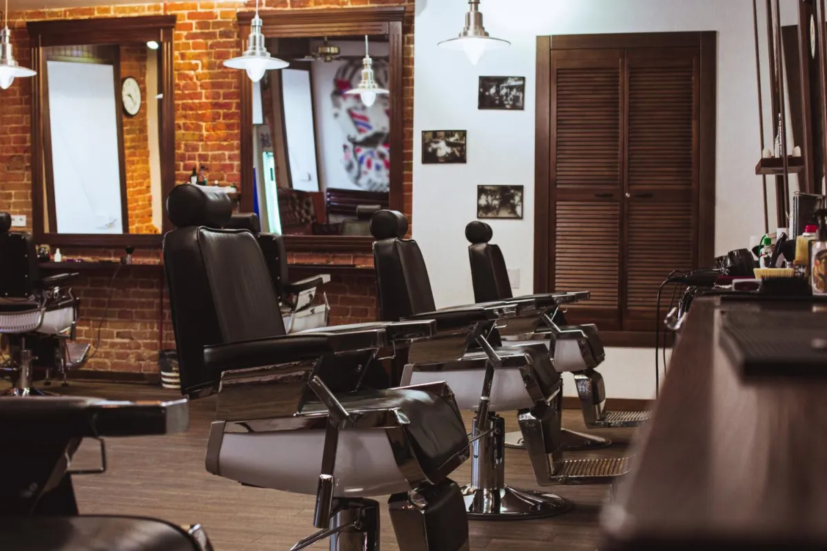 Classic leather barber chairs lined up inside the Cuts by Gage barbershop, featuring classic brick walls and a welcoming atmosphere for all ages.