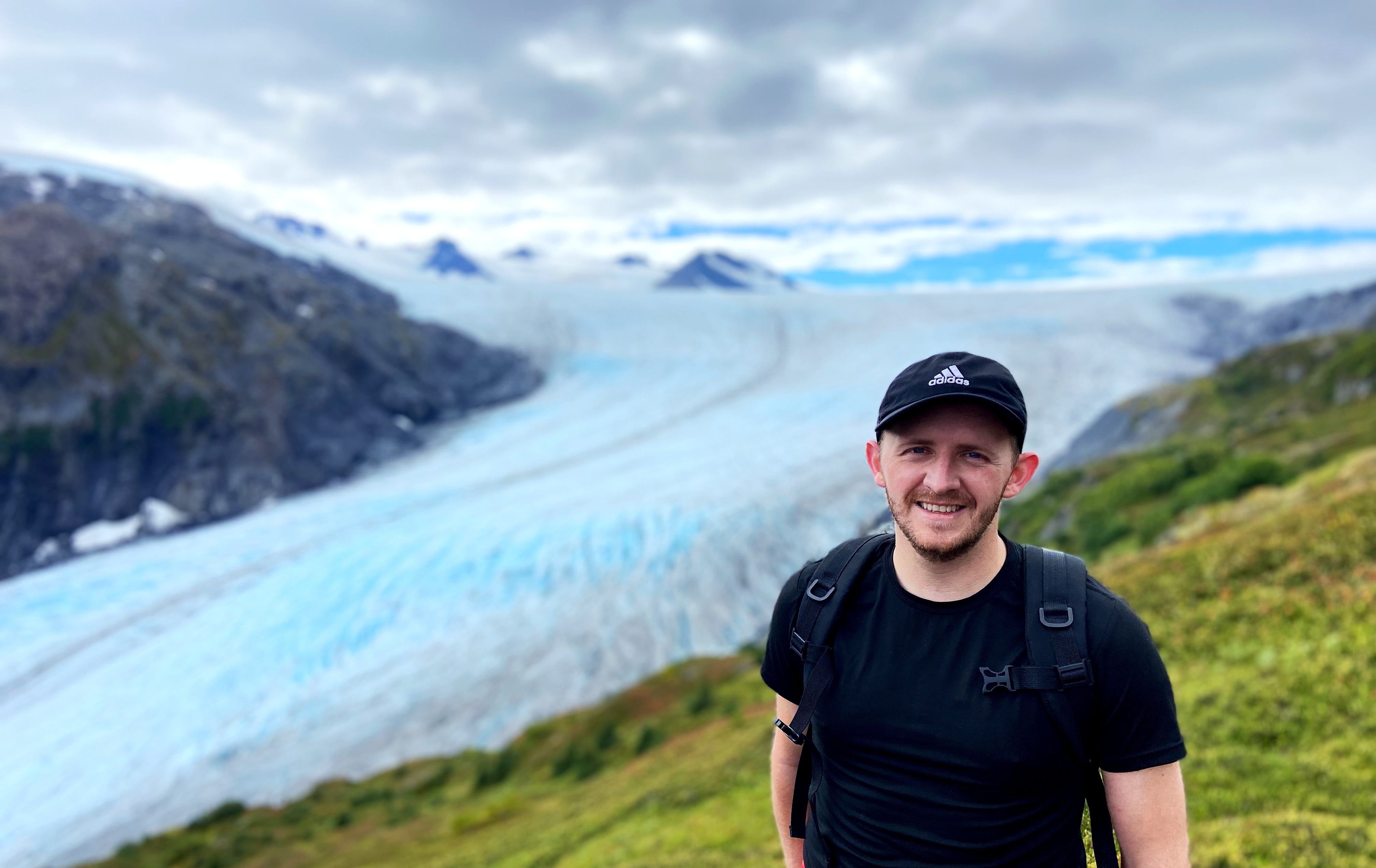 Brett in front of a glacier in Alaska after an international move.