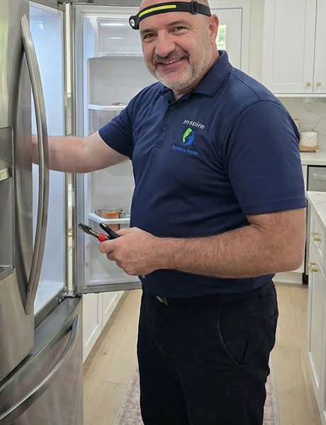 Igor from Inspire Appliance Repair fixing a large fridge for a customer