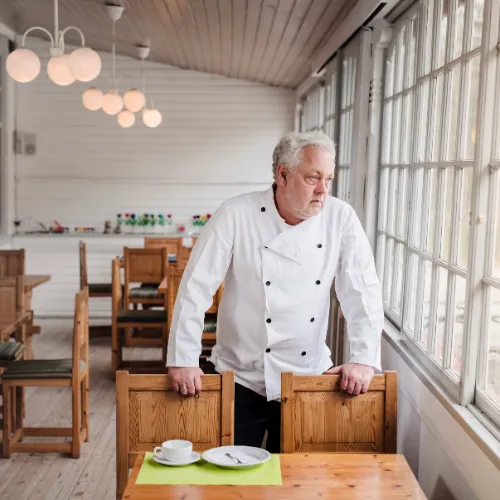 Restaurant owner staring at empty tables in is restaurant