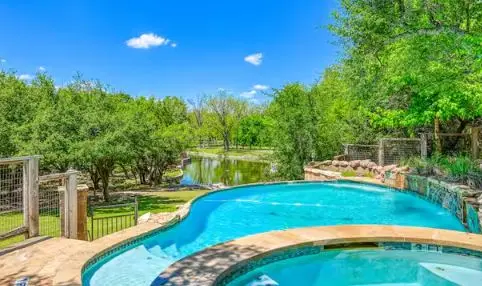 Vacation pool service from Canyon Lake Pool Service for a freeform pool and spa above a creek