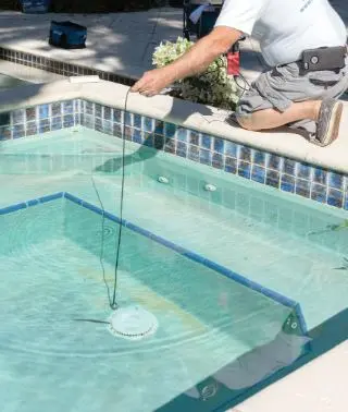 Technician running pool leak detection at an underwater light for Canyon Lake Pool Service