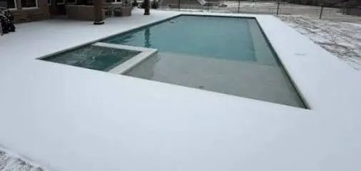 Snow-covered pool and deck where Canyon Lake Pool Service provides pool freeze protection