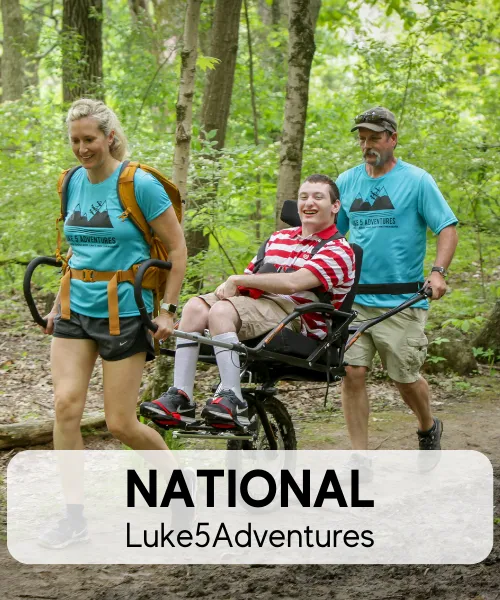 Picture of people in the forest helping a person with a disability, members of National Luke5Adventures