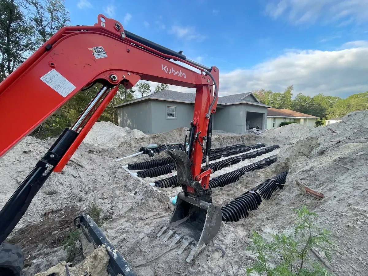 Septic drain field repair in Ocala Florida with excavator and new drainage pipes