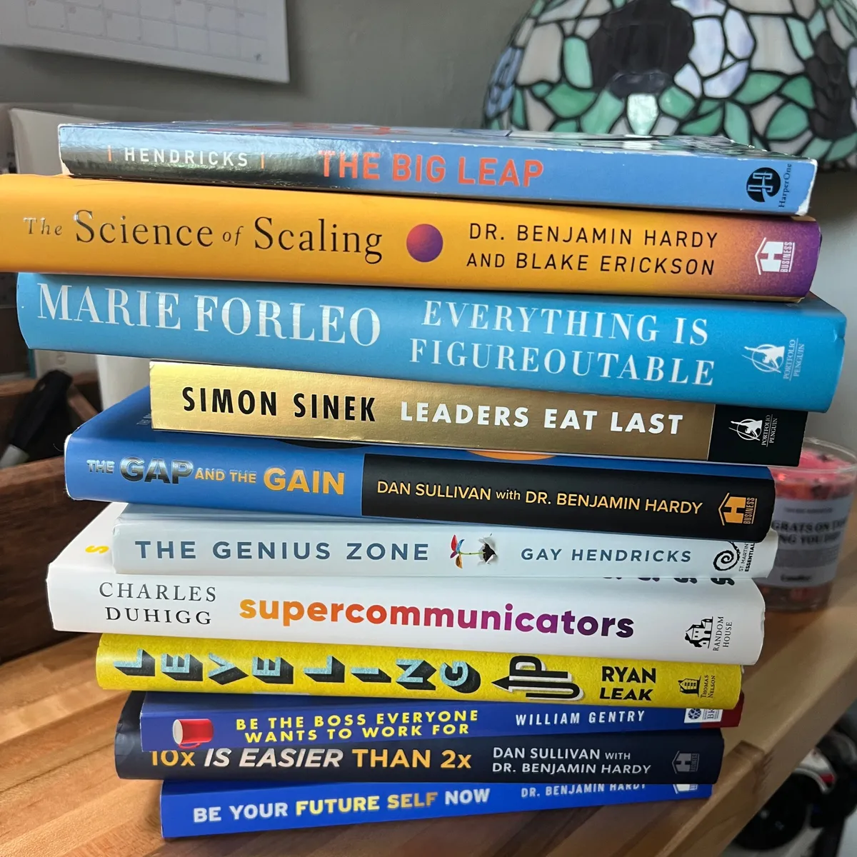 Stack of personal development and leadership books including The Big Leap, Everything Is Figureoutable, Leaders Eat Last, and Be Your Future Self Now