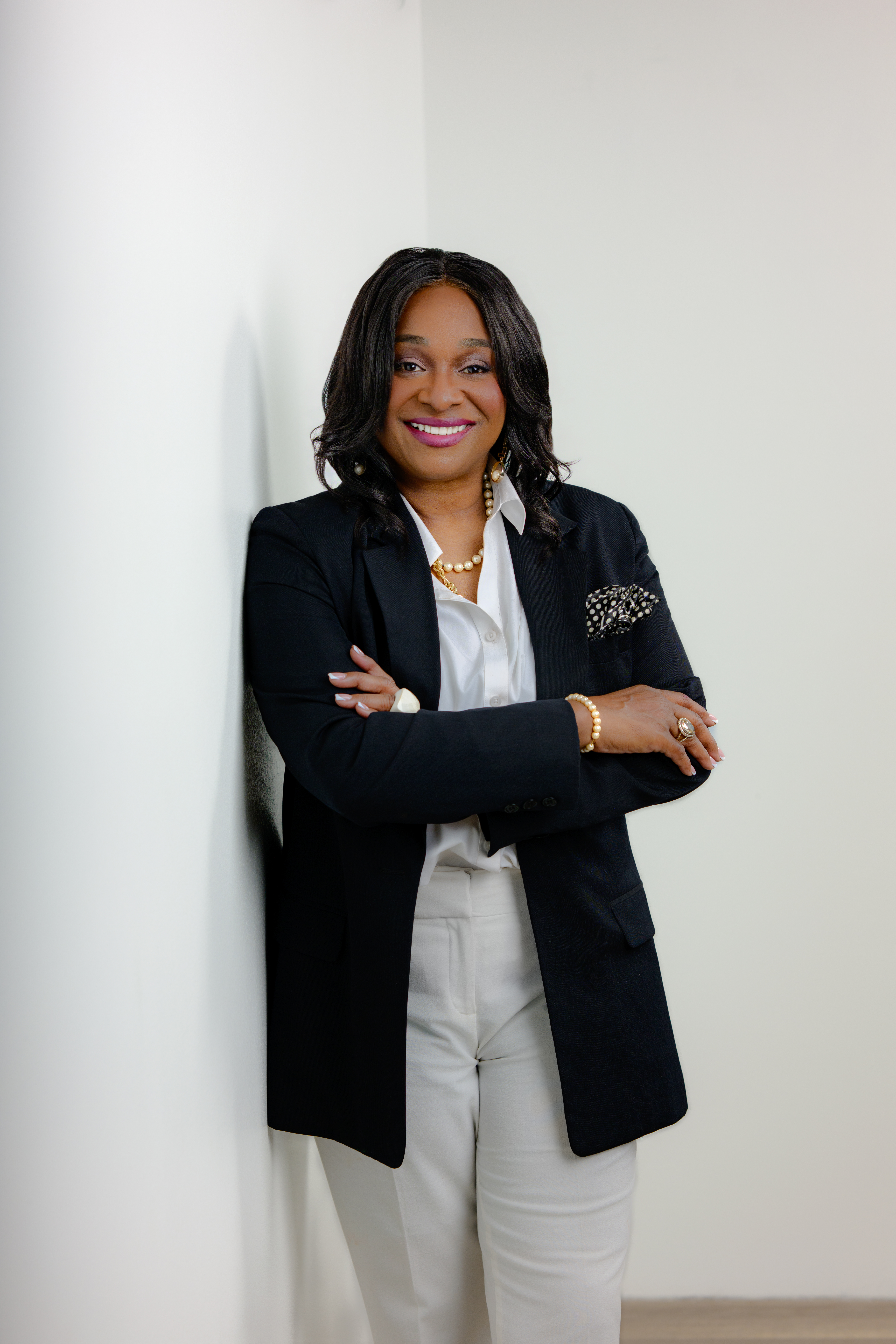 Regina Wagner, the Cash Flow Queen, wearing a professional black suit, providing financial strategy for business owners.