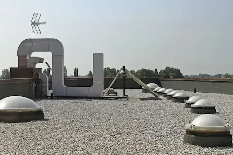 Flat commercial rooftop with gravel surface, dome skylights, and rooftop HVAC after completion