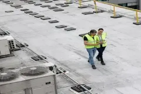 Two inspectors walking large commercial rooftop in Plymouth for Plymouth Commercial Roofing