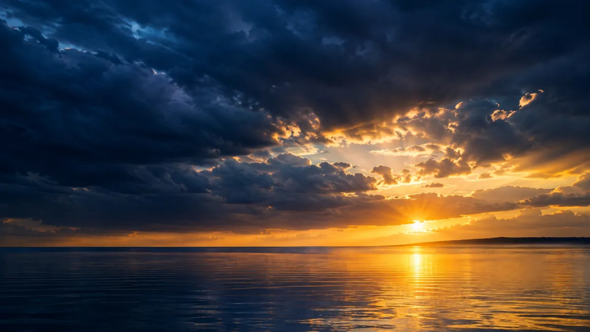 Dark storm clouds parting over calm water to reveal a warm golden sunrise breaking through, symbolizing hope after a long, dark season in marriage.