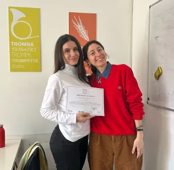 Studentessa con in mano un certificato di livello
