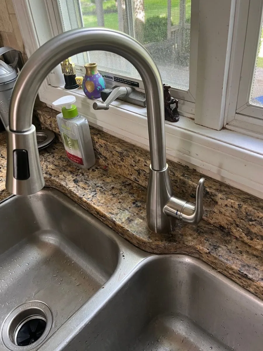 Stainless steel kitchen faucet and double-basin sink in an Amherst home.