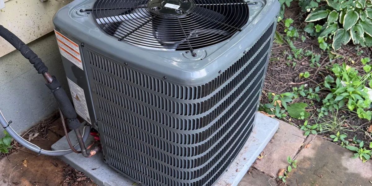 Outdoor central air conditioning condenser unit installed beside a residential home in Buffalo NY