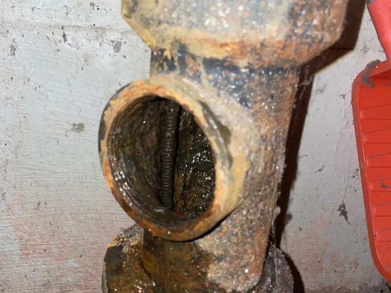 Drain cleaning cable inside a kitchen stack drain pipe