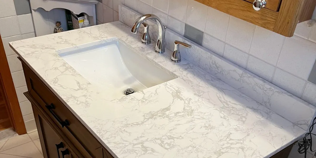 Bathroom vanity with undermount sink, chrome faucet, and marble-look countertop in a Amherst, NY home.
