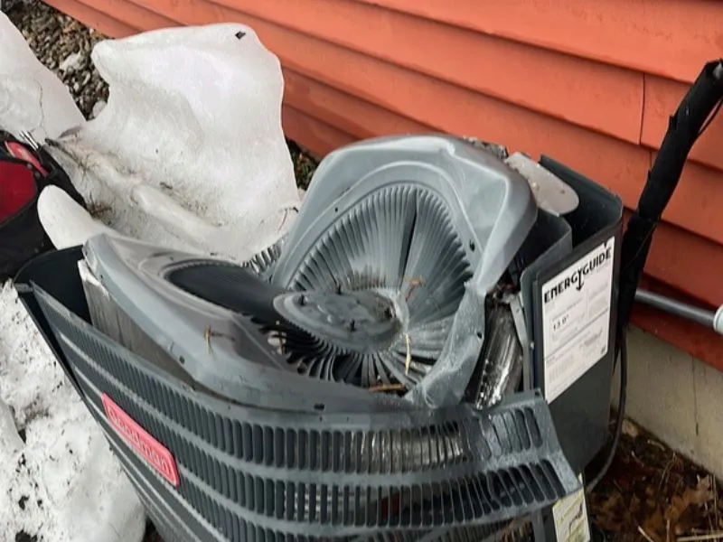 Outdoor air conditioning unit crushed by falling ice from damaged gutters at a Hamburg NY home