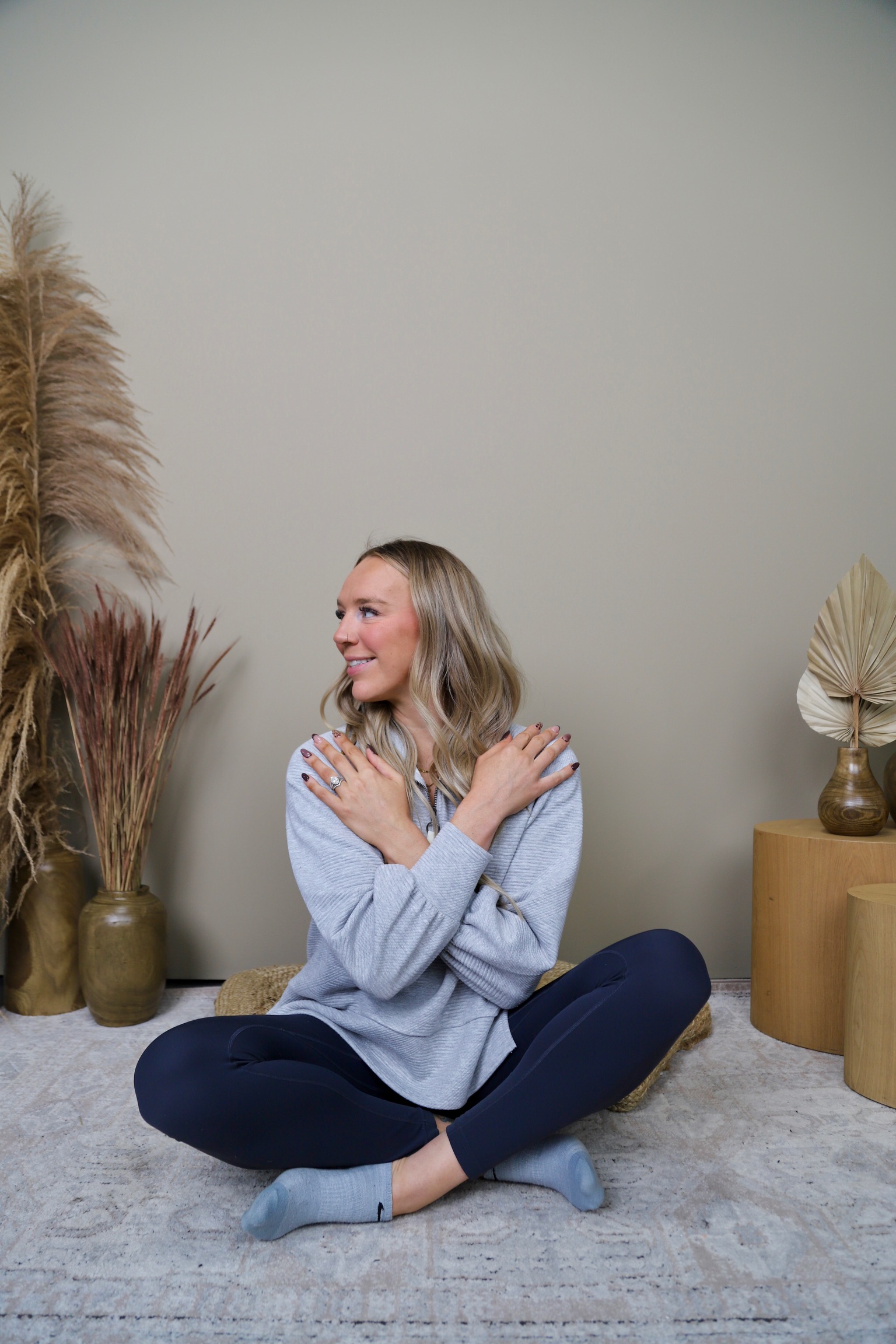 Portrait of Tiff, a woman in her late 30s with warm brown skin, short curly hair, wearing a soft pink blouse, smiling gently against a neutral background. 1:1 aspect ratio.