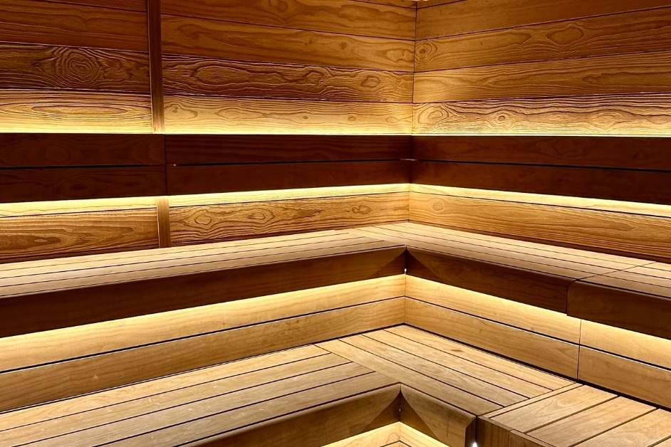 Modern custom wood sauna interior with bench seating and lighting