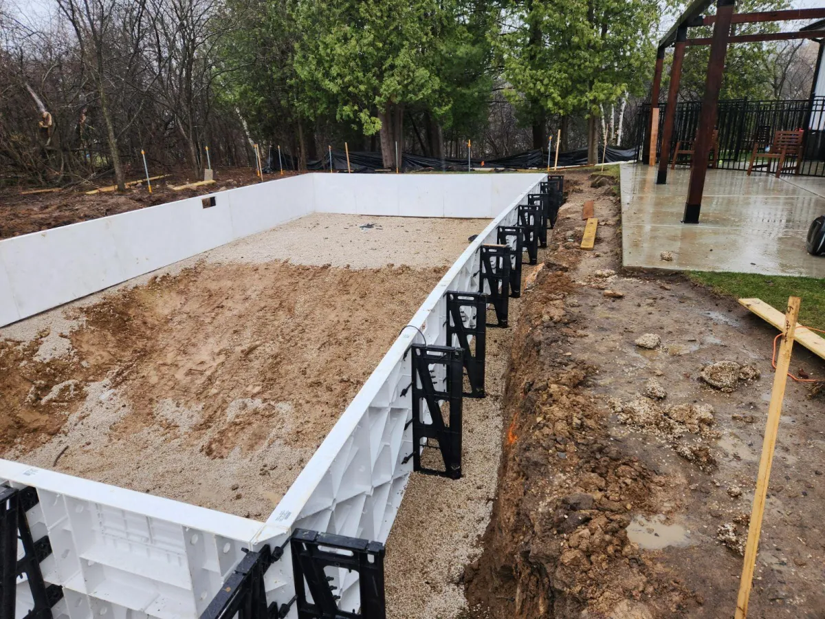 "Workers installing a new vinyl liner in a residential in-ground pool in Sun Prairie, WI."