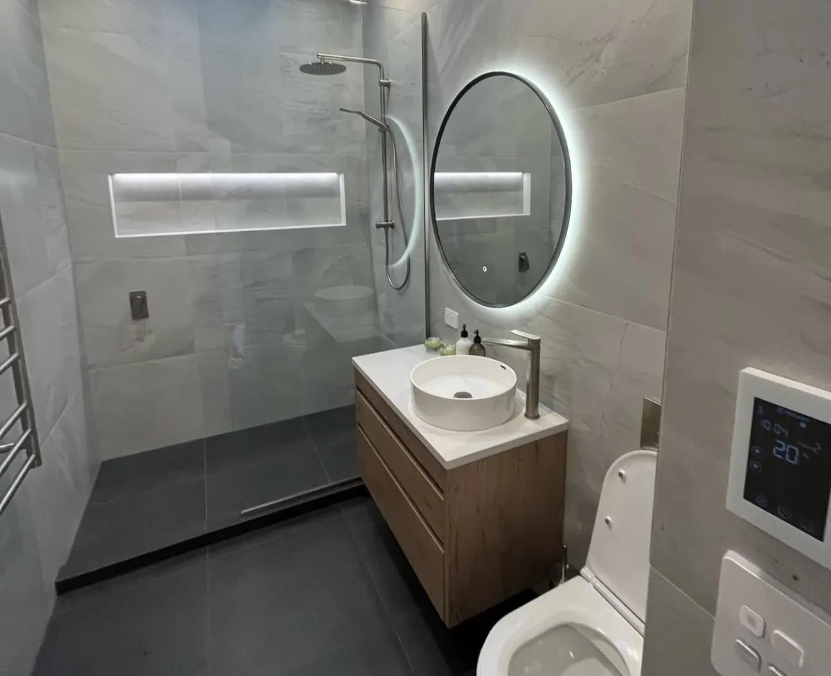 man in orange and black vest wearing white helmet holding yellow and black power tool