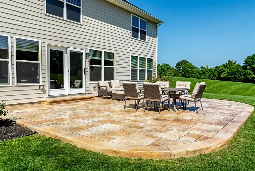 Freshly finished stamped concrete patio with earth tone coloring attached to a two-story upscale home in Kent, Ohio