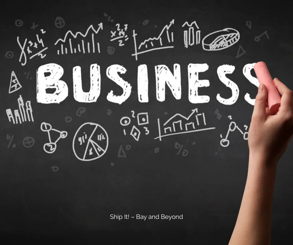 Hand writing the word “Business” on a chalkboard with charts and graphs, representing business planning, startup growth, and entrepreneurship concepts