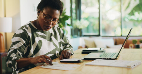 A woman reviewing her small business tax documents at a desk