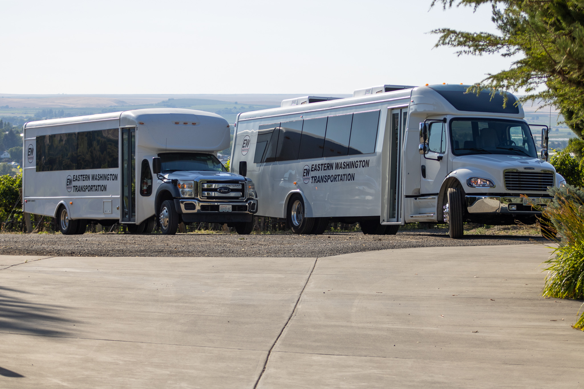 Modern charter bus driving through Eastern Washington at sunset