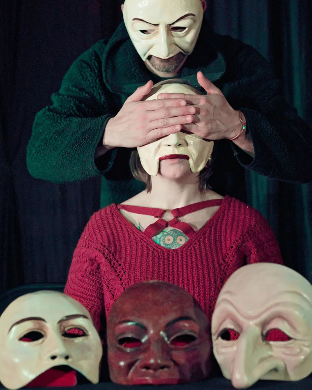 A candid group portrait of the 8 Seasons creative team gathered around a rehearsal table, animatedly discussing scripts and stage designs. The diverse group includes men and women of various ages and backgrounds, with sketches, props, and coffee cups scattered across the table, set in a warmly lit backstage studio.