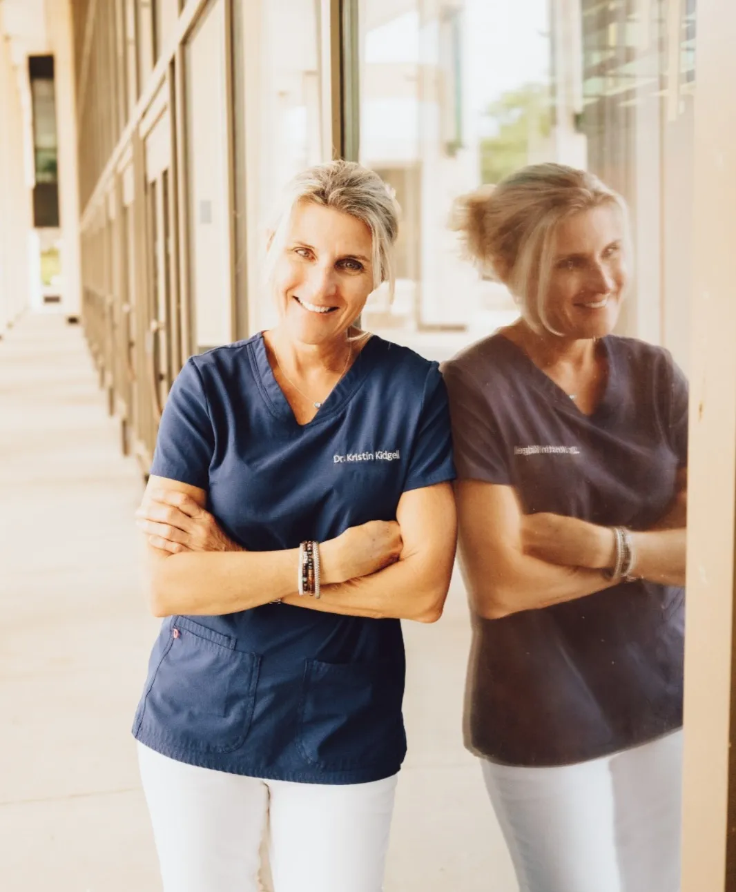 Dr. Kidgell, friendly and experienced chiropractor in St. Petersburg standing warmly in clinical attire