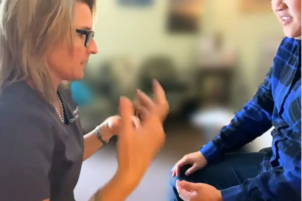 Dr. Kidgell listening attentively to a patient during an initial chiropractic consultation
