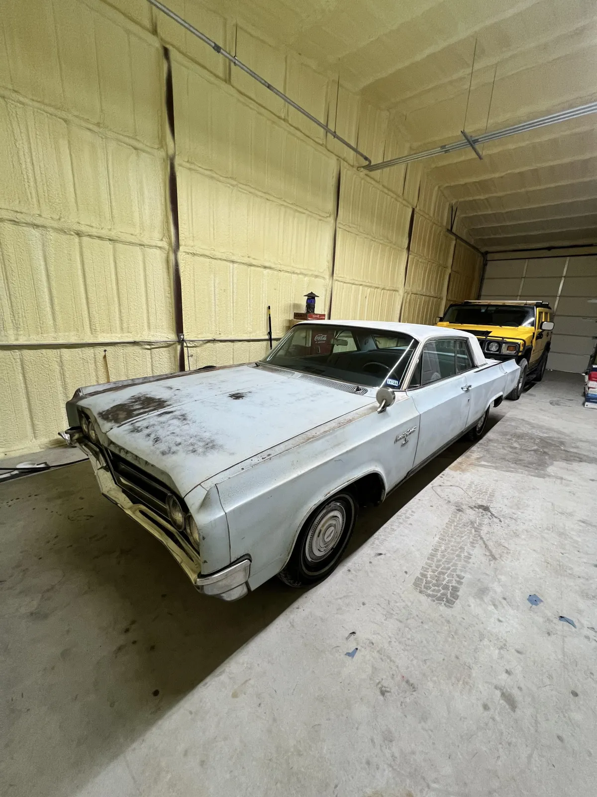 Old, worn-out car in a garage, showcasing potential for restoration by Kanewske Motors, highlighting the business's car revitalization services.