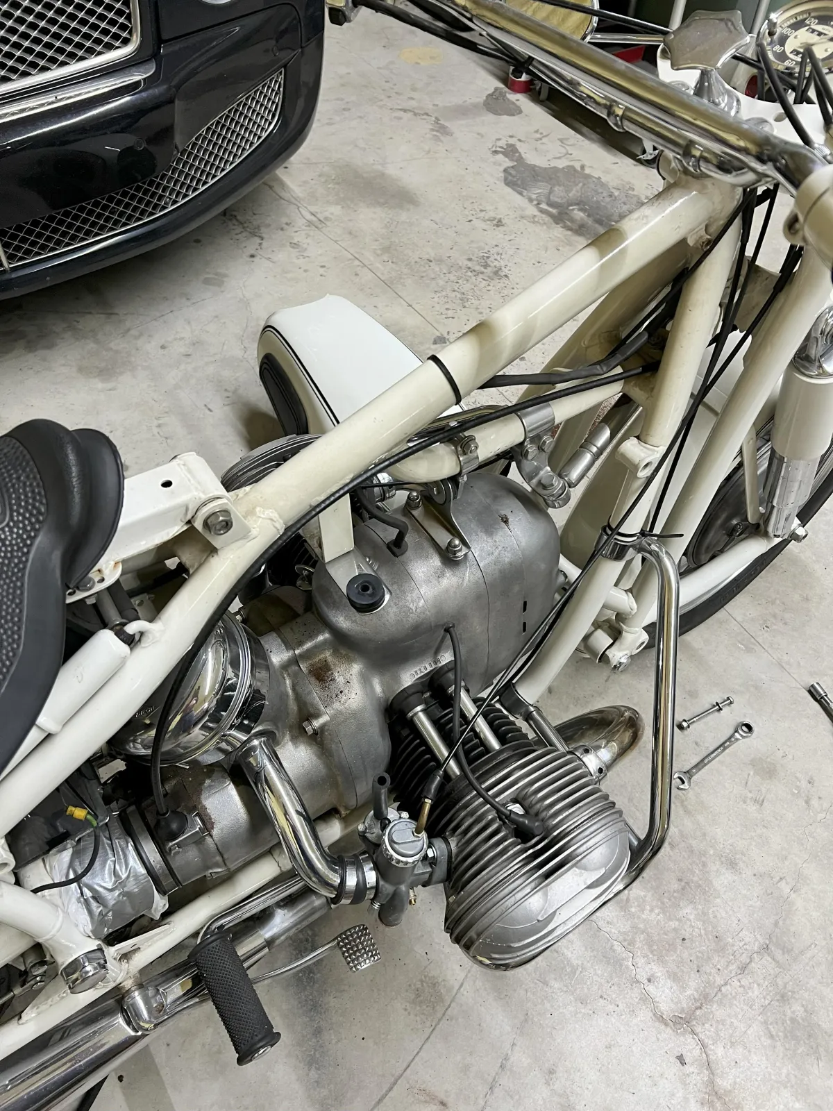 Motorcycle engine and frame in automotive workshop, showcasing restoration details relevant to Kanewske Motors' services.