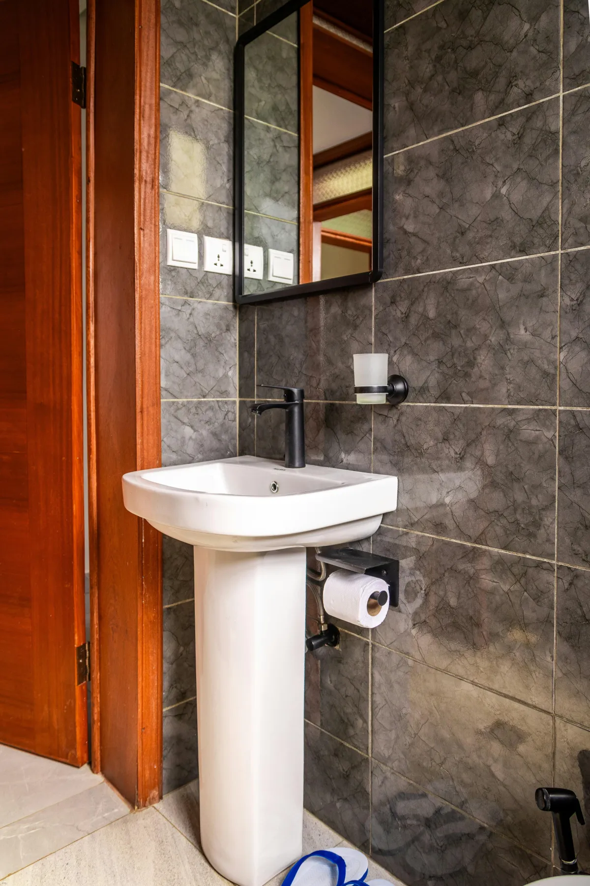 toilet room white sink with black tiles