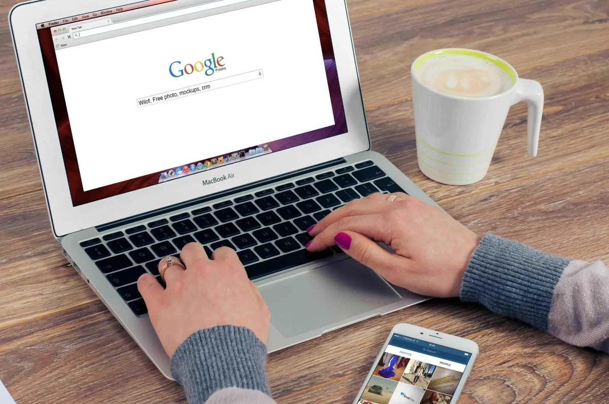 A person typing on a laptop with the Google homepage open, representing someone searching for services or businesses through Google Ads