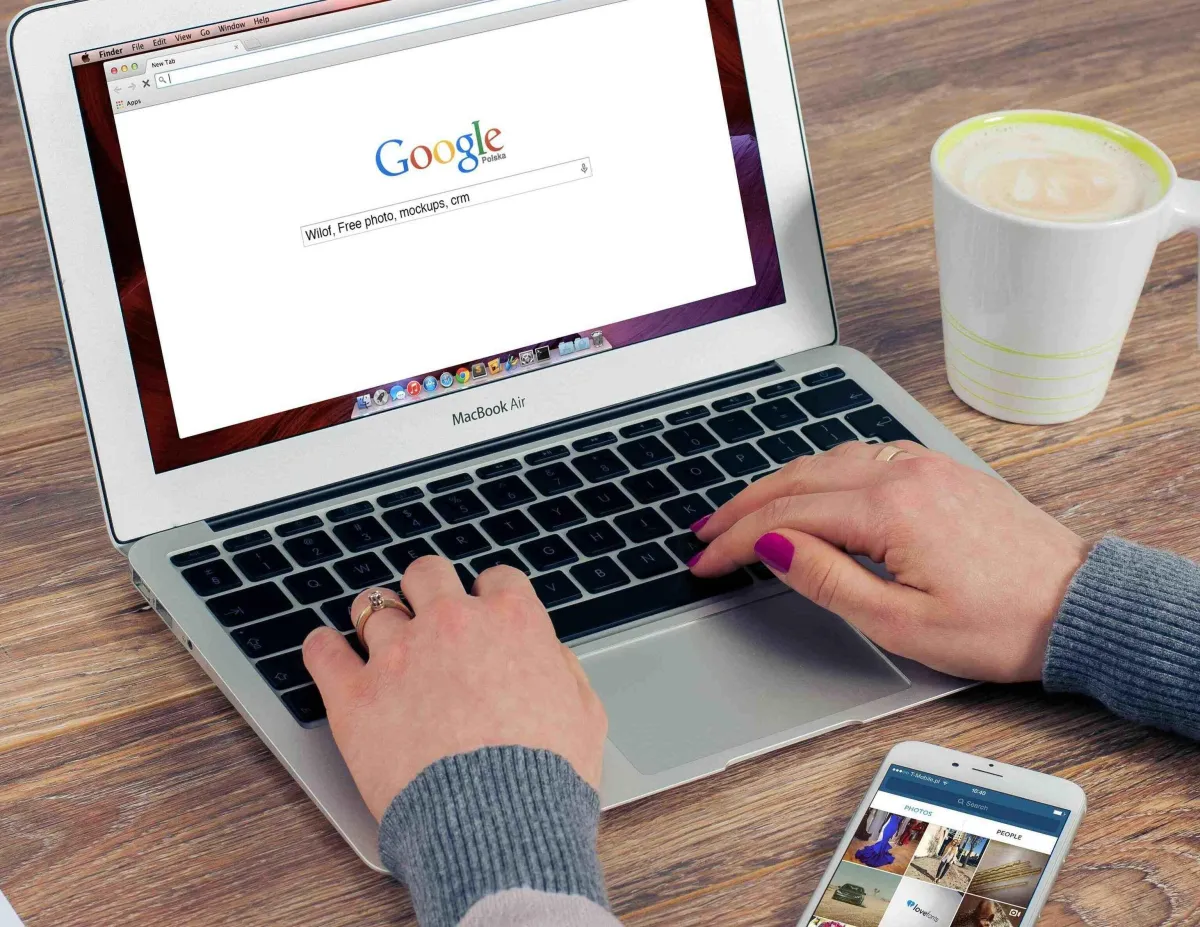 A person typing on a laptop with the Google homepage open, representing someone searching for services or businesses through Google Ads