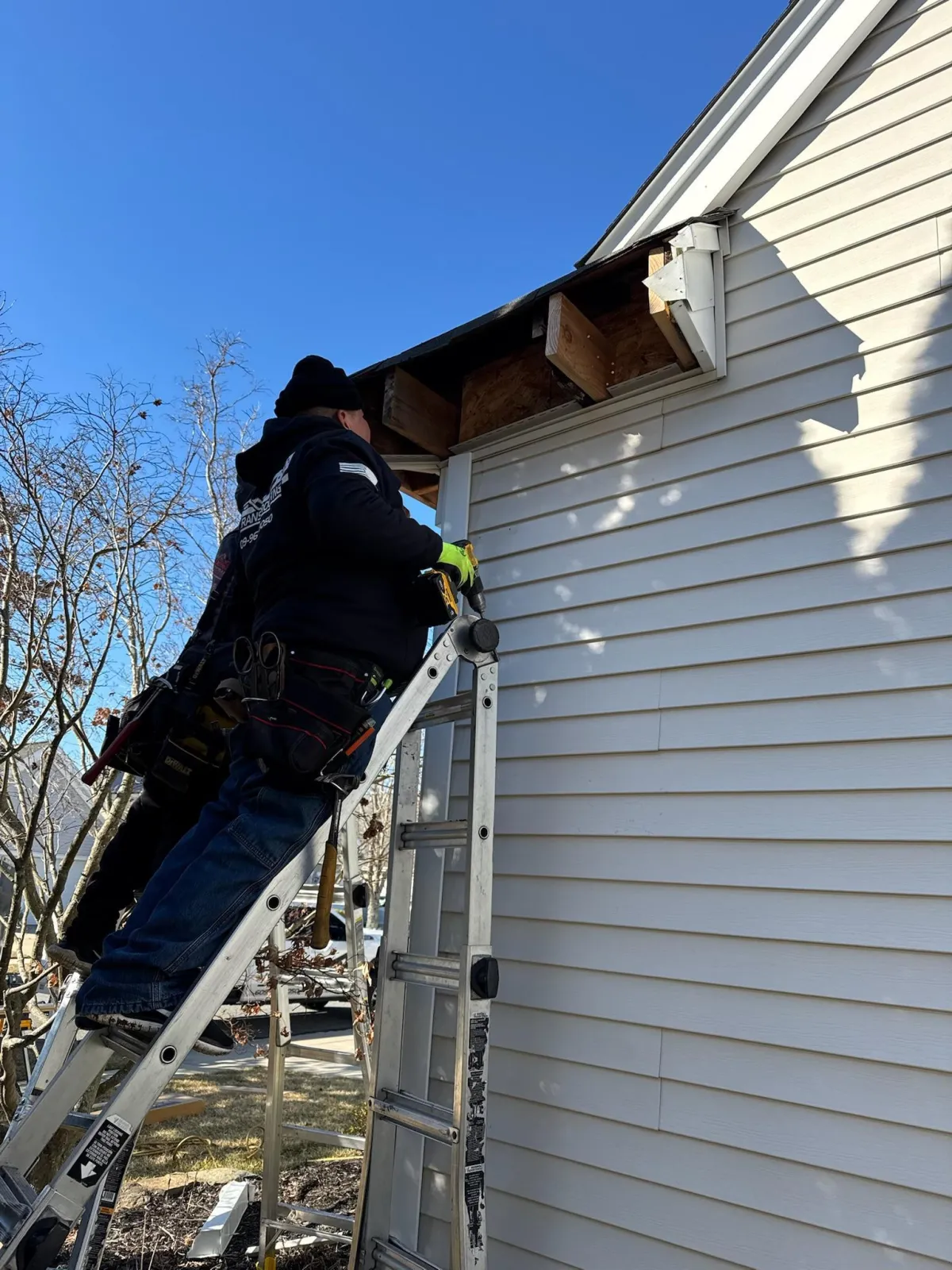 Veterans Roofing crew member repairing siding and fascia in South Jersey