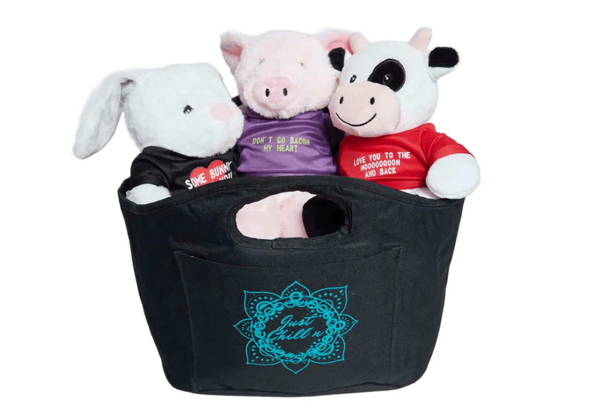 Bunny, pig and cow plush toys wearing printed shirts inside a black “Just Chill'n” tote