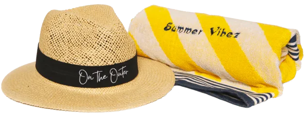 Branded straw hat beside rolled yellow Summer Vibez towel