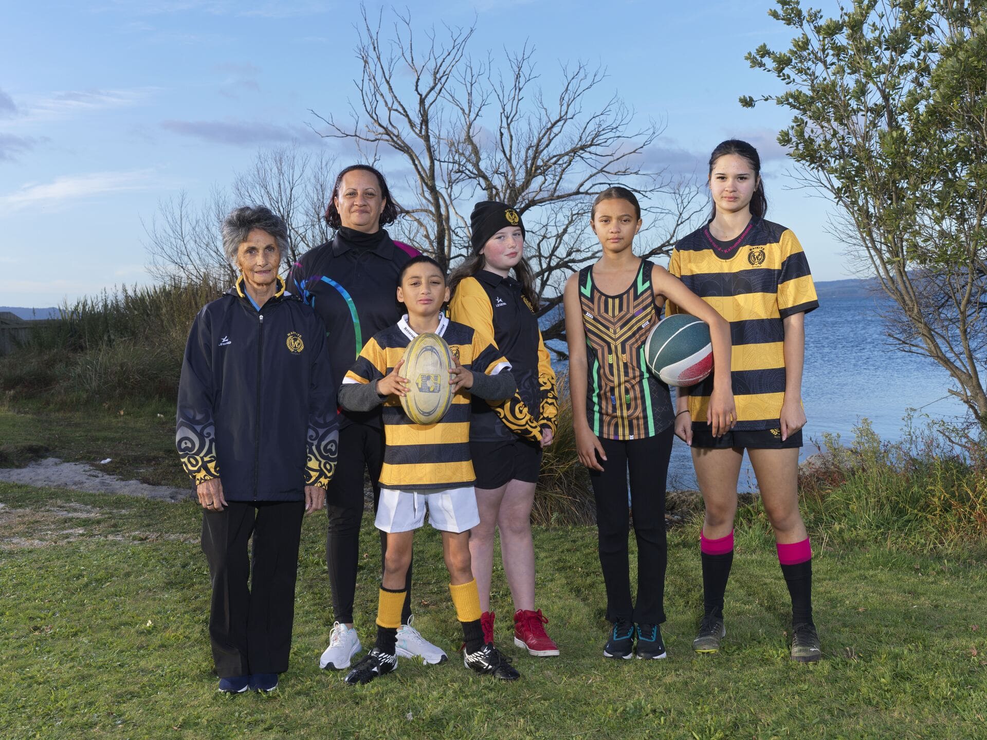Group wearing coordinated black and gold sports uniforms, jackets and playing tops