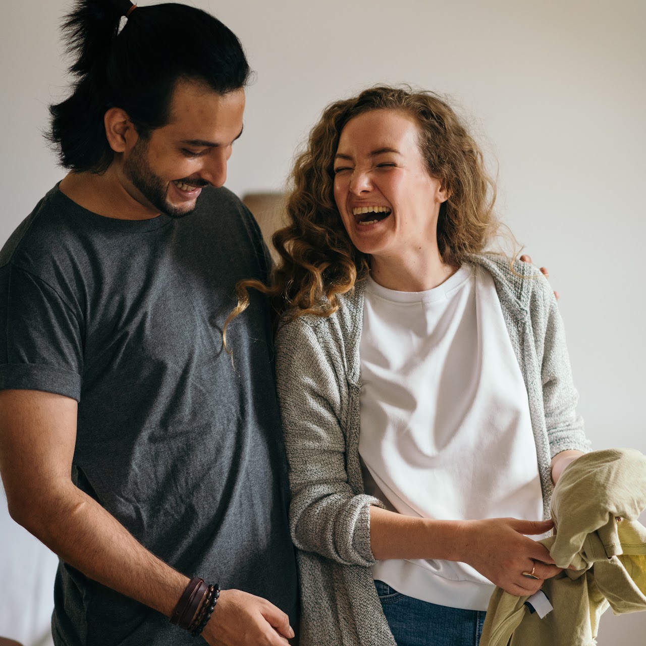 Close-up of a smiling couple carrying moving boxes in warm natural light; candid, diverse, family-friendly scene with faces clearly visible, high resolution, no watermark
