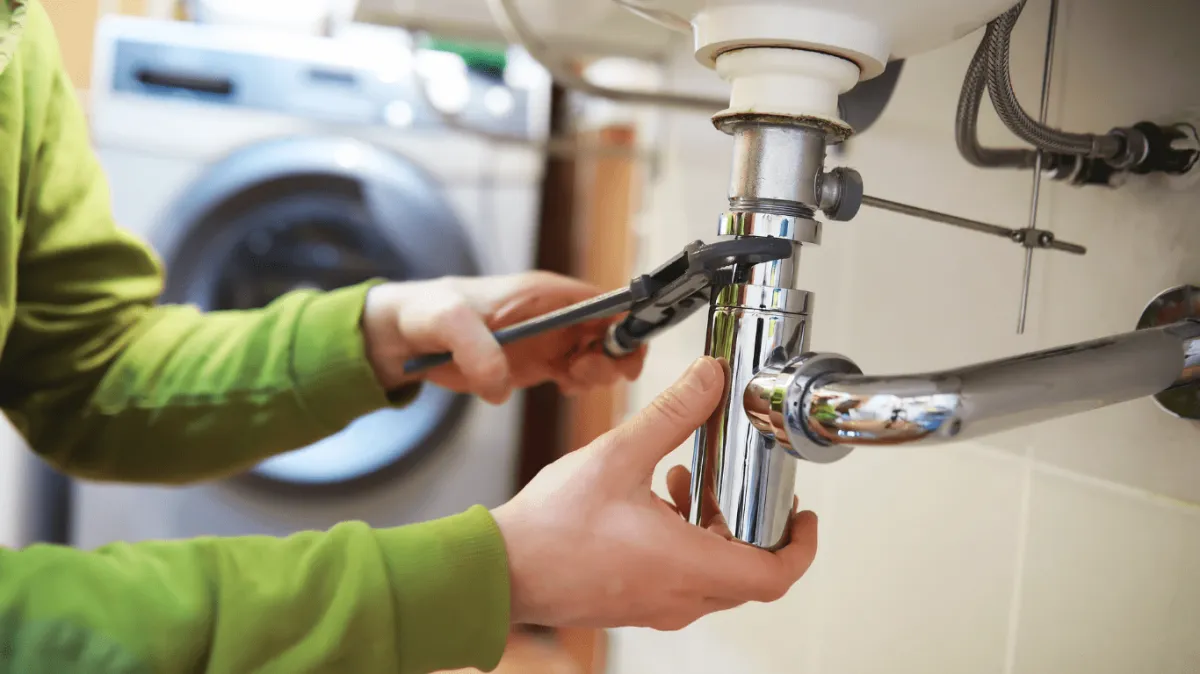 Licensed plumber fixing a leak repair under a bathroom sink in San Antonio, Tx