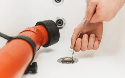 Plumber cleaning a clogged drain in San Antonio